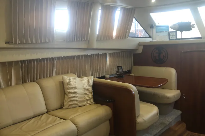 Slide: The Image of Interior of 2005 Carver 41 Cockpit Motor Yacht with beige seating and wooden table. - 39