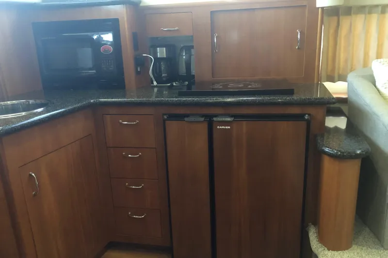 Slide: The Image of 2005 Carver 41 Cockpit Motor Yacht kitchen with microwave, coffee maker, and mini fridge. - 41
