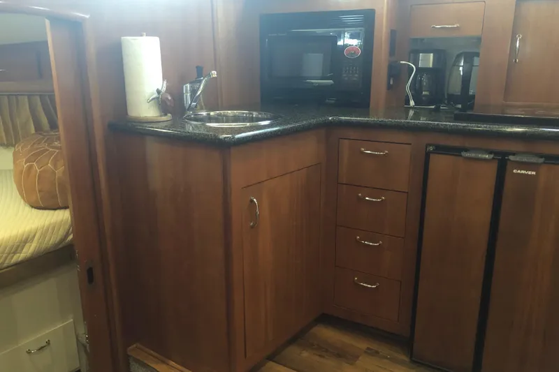 Slide: The Image of 2005 Carver 41 Cockpit Motor Yacht kitchen with microwave, sink, and mini-fridge. - 42