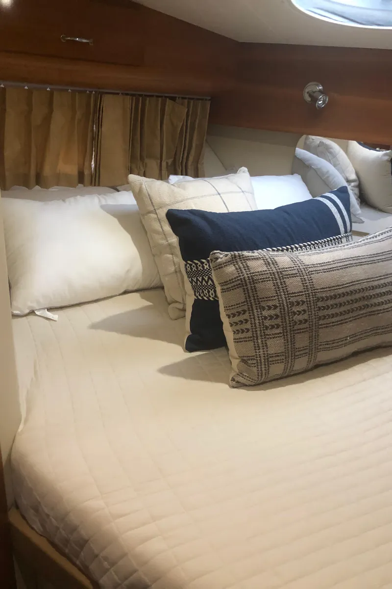 Slide: The Image of 2005 Carver 41 Cockpit Motor Yacht bedroom with cozy bedding and decorative pillows. - 44