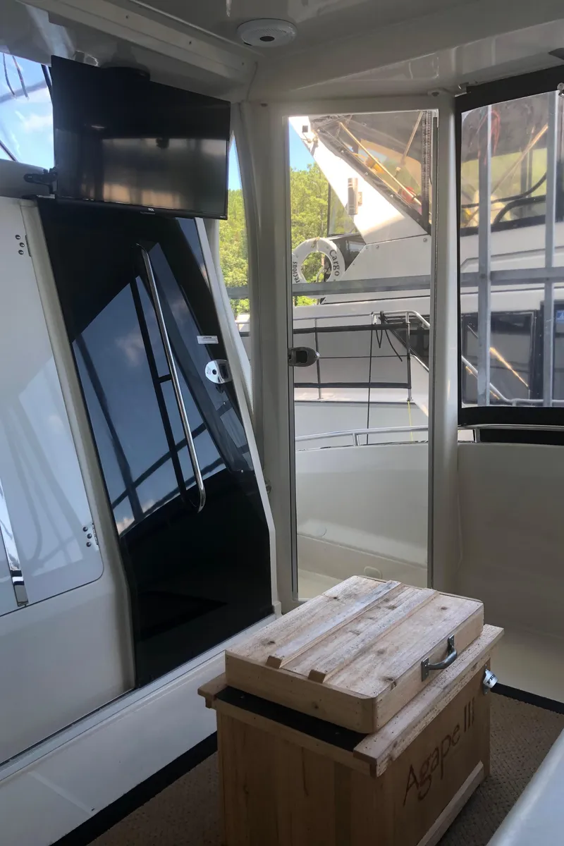 Slide: The Image of 2005 Carver 41 Cockpit Motor Yacht interior with TV and wooden storage box. - 15
