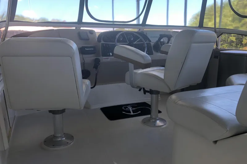 Slide: The Image of 2005 Carver 41 Cockpit Motor Yacht helm with white captain chairs and navigation controls. - 24
