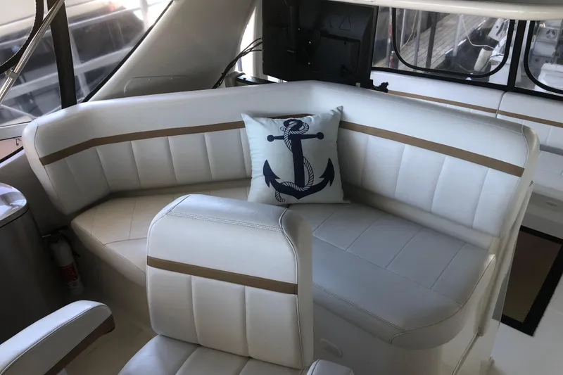 Slide: The Image of 2005 Carver 41 Cockpit Motor Yacht interior with white leather seating and anchor pillow. - 25