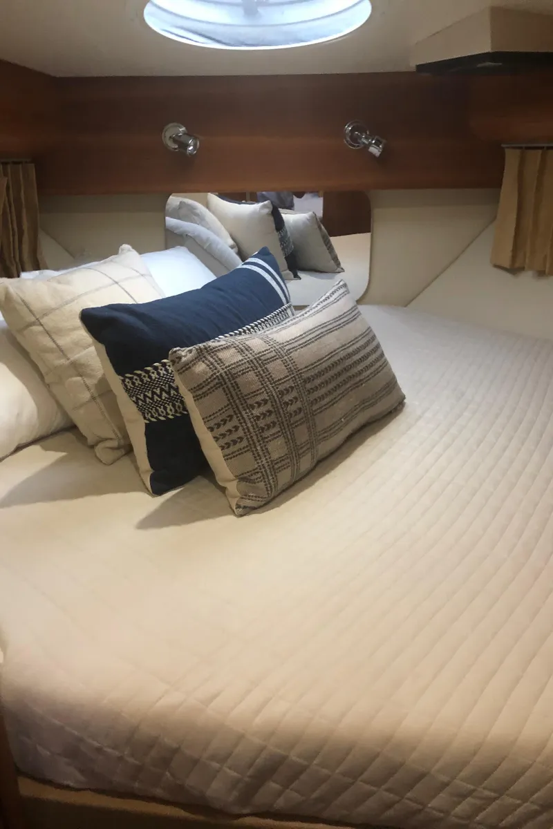 Slide: The Image of Cozy bedroom in 2005 Carver 41 Cockpit Motor Yacht with plush pillows and natural light. - 45