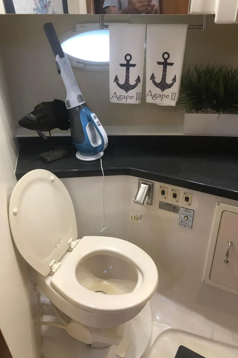 Slide: The Image of 2005 Carver 41 Cockpit Motor Yacht bathroom with toilet and cleaning supplies. - 46