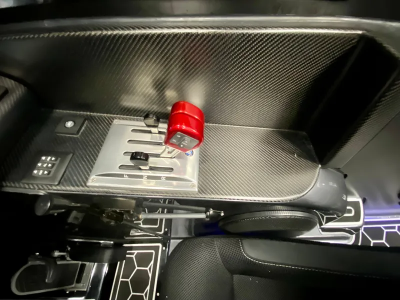 Slide: The Image of 2024 Nitra Boats 30 SkyTop control panel with carbon fiber finish and red throttle lever. - 19