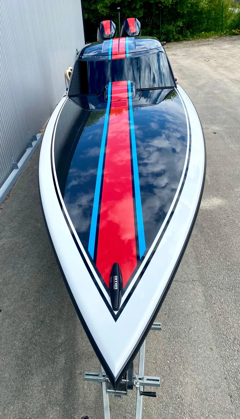 Slide: The Image of 2024 Nitra Boats 30 SkyTop with sleek black, red, and blue design. - 4