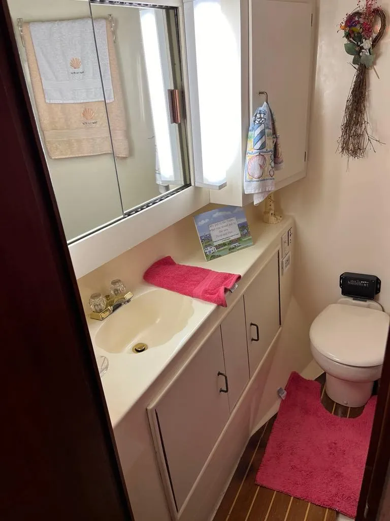 Slide: The Image of Bathroom in 1989 Ocean Yachts 44 Super Sport Custom with pink accents and wooden flooring. - 13