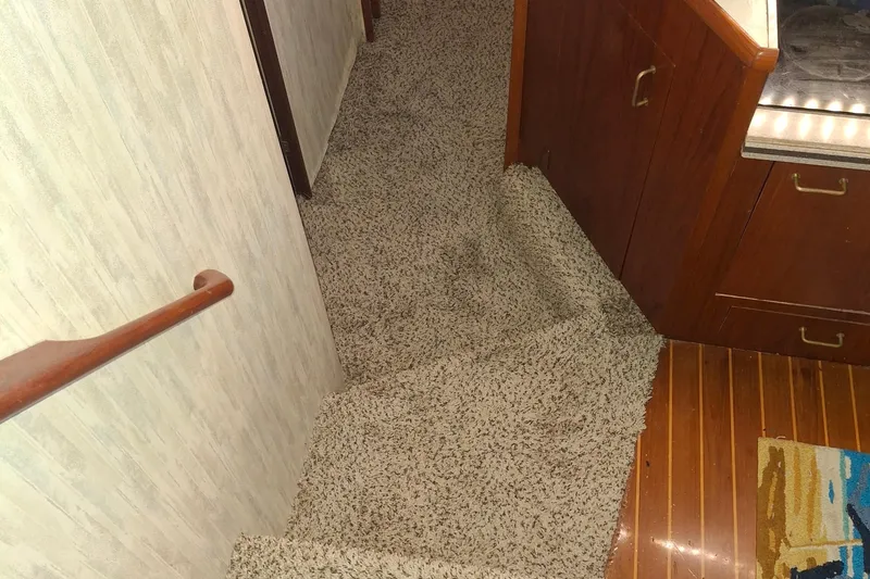 Slide: The Image of Carpeted stairs and wooden cabinets inside 1989 Ocean Yachts 44 Super Sport Custom. - 18