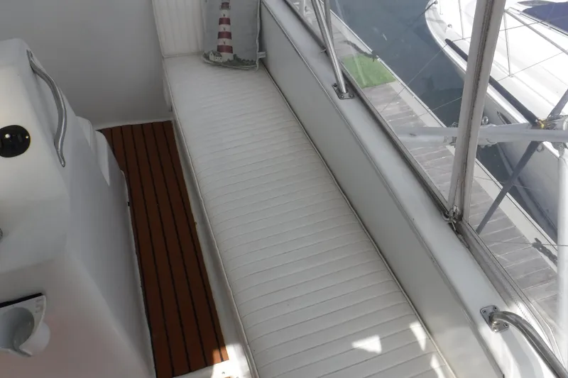 Slide: The Image of 1989 Ocean Yachts 44 Super Sport Custom interior with white seating and wooden flooring. - 42