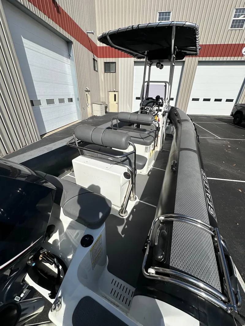 Slide: The Image of 2013 Sealegs 7.1m RIB boat with seating and canopy in a parking lot. - 6