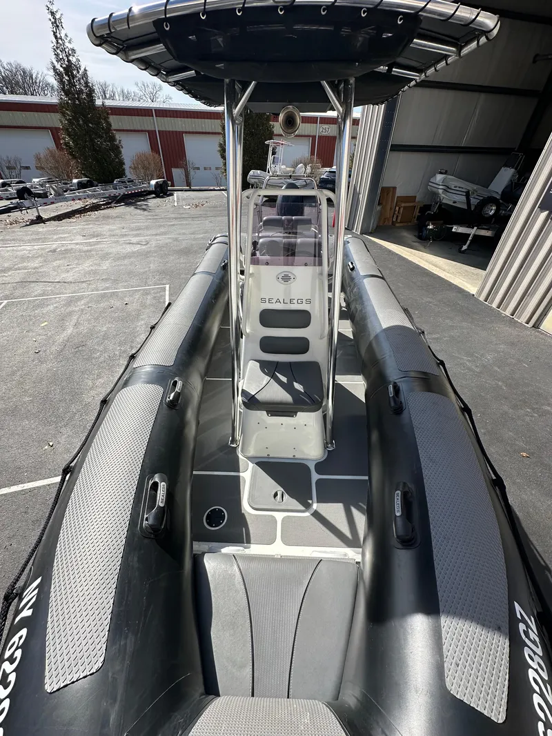 Slide: The Image of 2013 Sealegs 7.1m RIB boat with center console and T-top in a storage facility. - 7