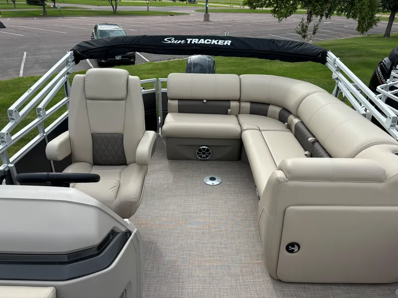 Slide: The Image of 2024 Sun Tracker Party Barge 20 DLX interior with beige seating and steering console. - 7