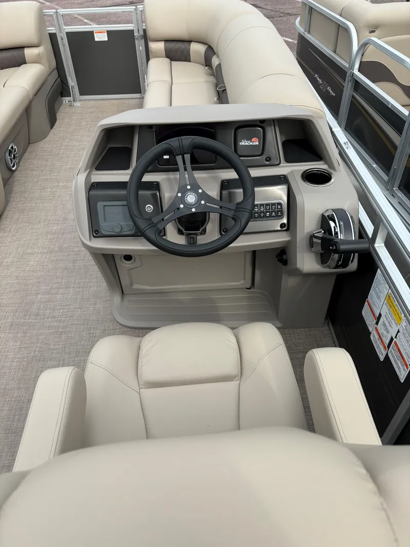 Slide: The Image of 2024 Sun Tracker Party Barge 20 DLX pontoon boat helm with beige seating and steering console. - 8