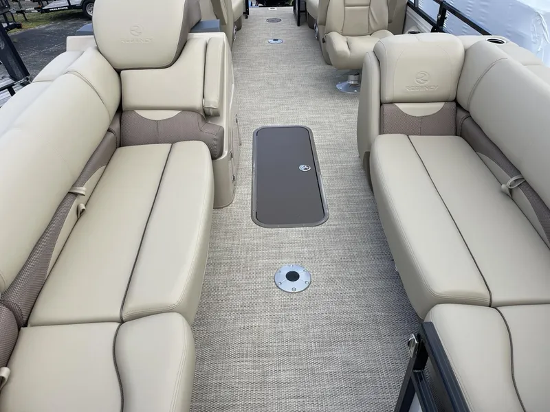 Slide: The Image of 2024 Regency 230 DL3 boat interior with beige seating and carpeted floor. - 5