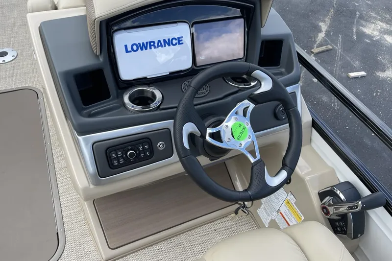 Slide: The Image of 2024 Regency 230 DL3 boat dashboard with Lowrance display and steering wheel. - 8