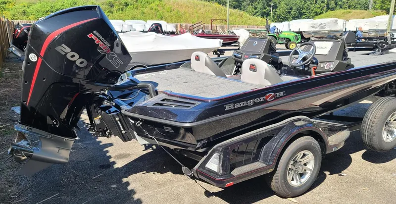 Slide: The Image of 2024 Ranger Z518 Garmin Ranger Cup boat with powerful 200 HP engine, parked outdoors. - 2