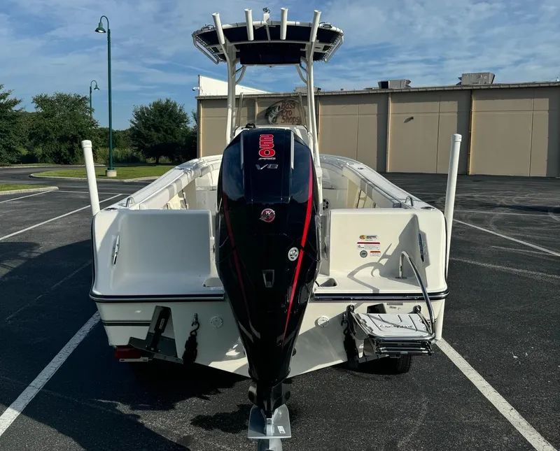 Slide: The Image of 2024 Mako 214 CC boat with powerful outboard motor, parked in a lot. - 4