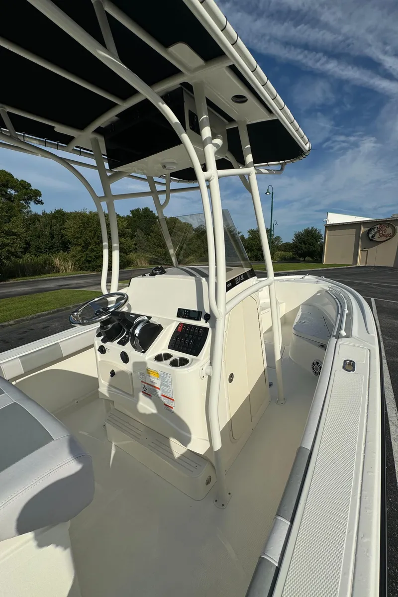 Slide: The Image of 2024 Mako 214 CC center console boat with T-top and modern dashboard. - 6