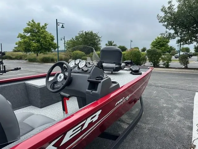 Slide: The Image of 2024 Tracker Pro 170 boat with red exterior, parked outdoors. - 2