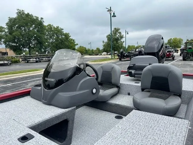 Slide: The Image of 2024 Tracker Pro 170 boat with gray seating and console, parked outdoors. - 3
