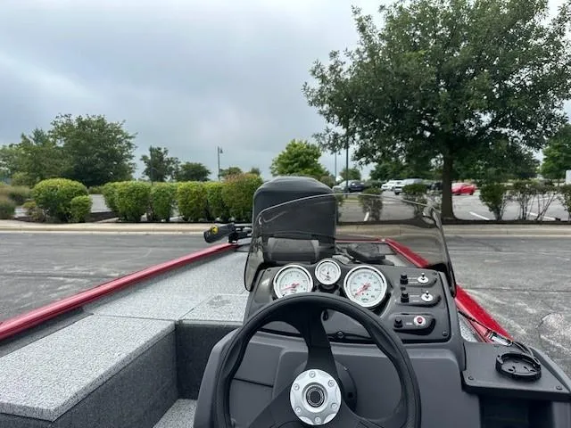 Slide: The Image of 2024 Tracker Pro 170 boat dashboard with steering wheel and gauges, parked outdoors. - 4