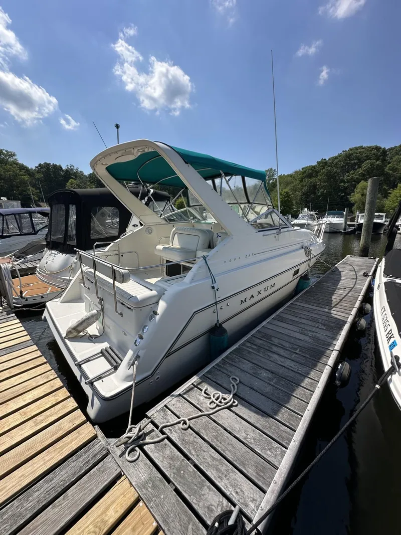 Slide: The Image of 1998 Maxum 2800 SCR boat docked at a marina on a sunny day. - 1