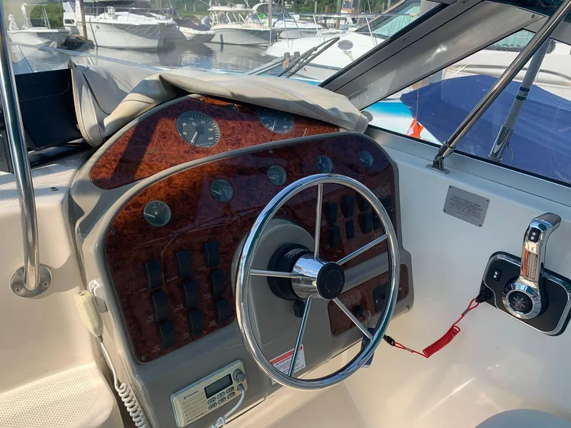 Slide: The Image of 1998 Maxum 2800 SCR boat dashboard with steering wheel and control panel. - 11