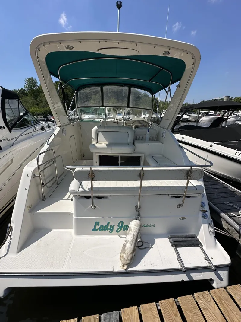 Slide: The Image of 1998 Maxum 2800 SCR boat docked, featuring a spacious cockpit and green canopy. - 2