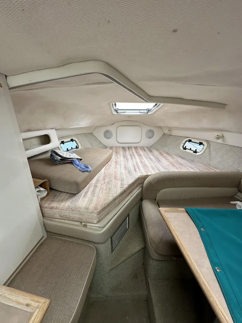 Slide: The Image of 1998 Maxum 2800 SCR cabin interior with bed, seating, and skylight. - 25