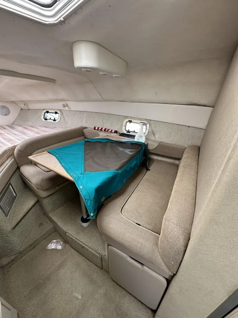 Slide: The Image of Interior cabin of a 1998 Maxum 2800 SCR boat with seating and table. - 26