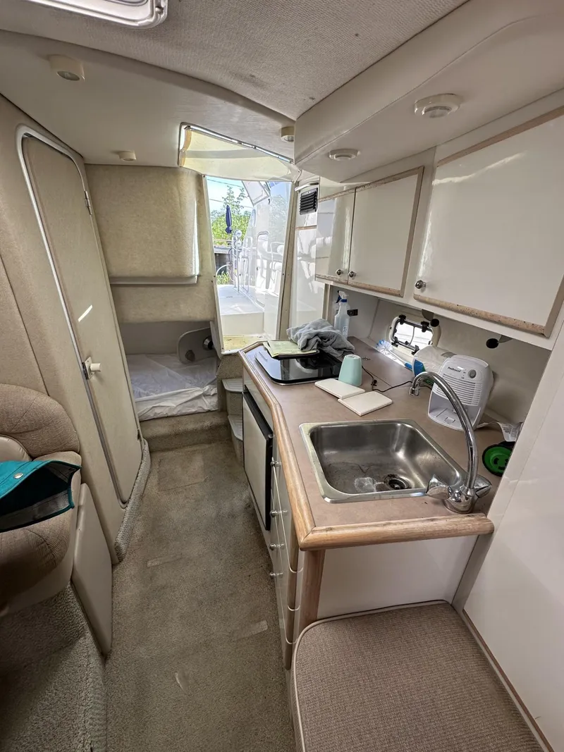 Slide: The Image of 1998 Maxum 2800 SCR boat interior with kitchenette and sleeping area. - 27