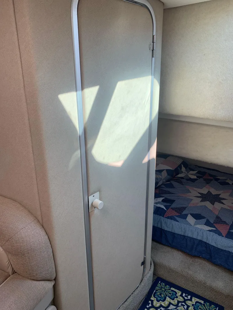 Slide: The Image of Interior cabin of a 1998 Maxum 2800 SCR boat with a closed door and bed. - 28