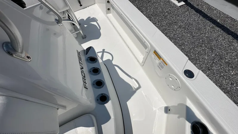 Slide: The Image of 2024 Frontier 2104 boat interior with rod holders and seating area. - 10