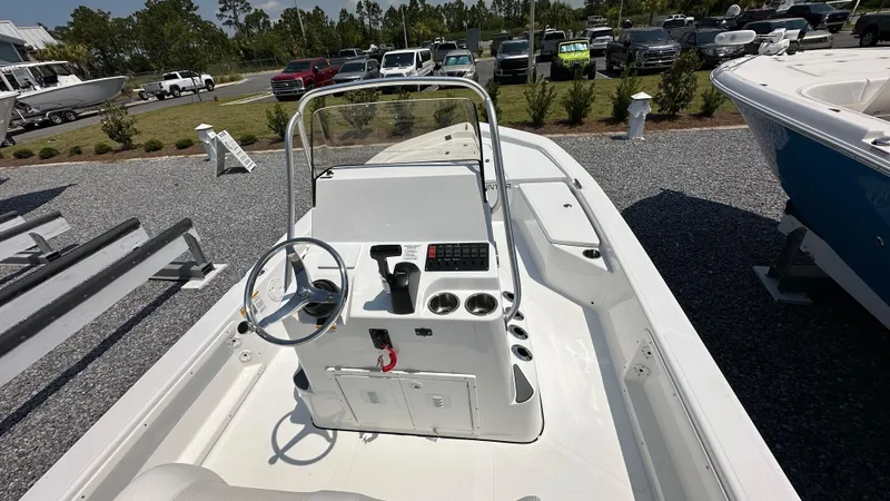 Slide: The Image of 2024 Frontier 2104 boat console with steering wheel and controls, parked in a lot. - 11