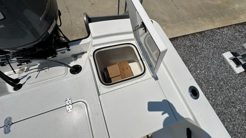 Slide: The Image of 2024 Frontier 2104 boat with open storage compartment and outboard motor. - 17