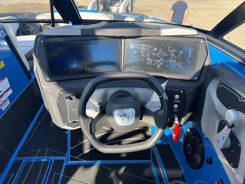 Slide: The Image of 2023 Centurion Fi25 boat dashboard with dual screens and steering wheel. - 8