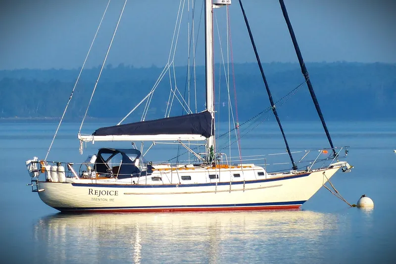 Slide: The Image of Pacific Seacraft 37 sailboat from 2000, named "Rejoice," anchored on calm water. - 0