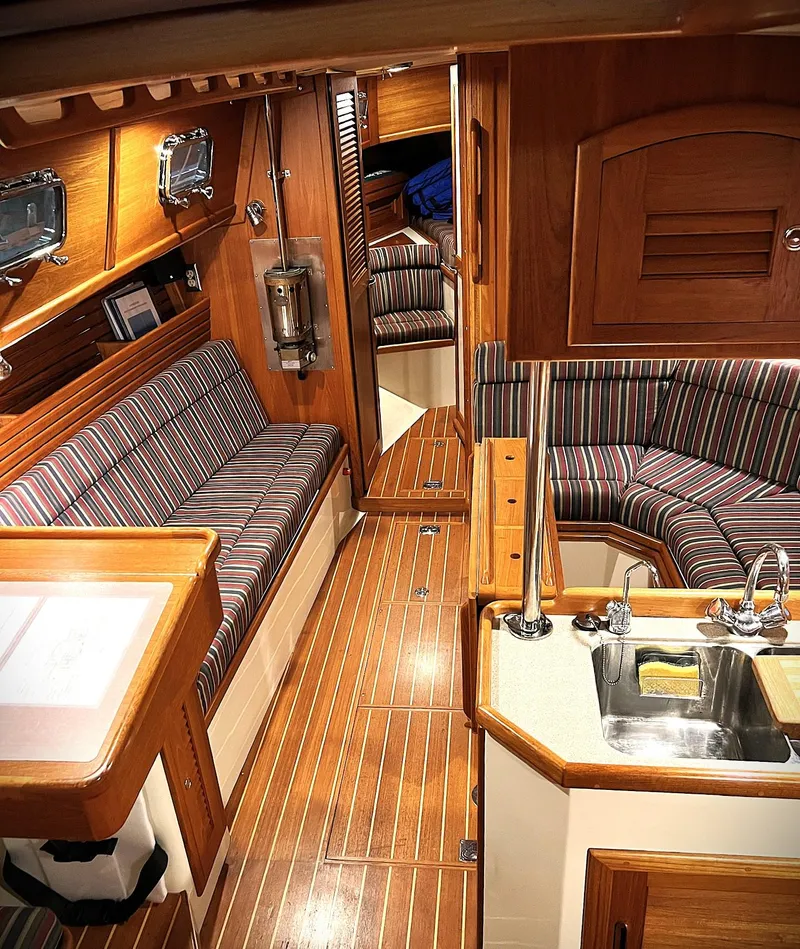 Slide: The Image of Interior of 2000 Pacific Seacraft 37 sailboat with wood finish and striped upholstery. - 1