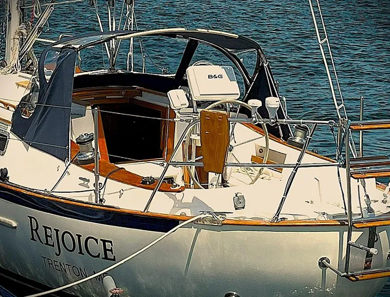 Slide: The Image of Pacific Seacraft 37 sailboat, 2000 model, named "Rejoice" docked in calm waters. - 10