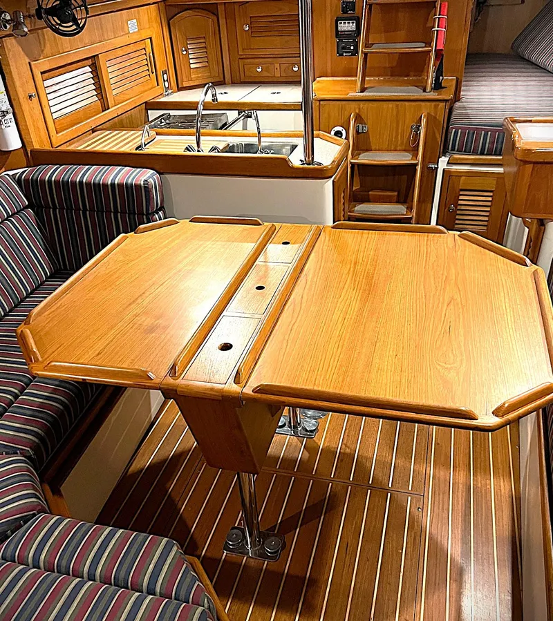 Slide: The Image of Interior of 2000 Pacific Seacraft 37 sailboat with wooden table and striped seating. - 3