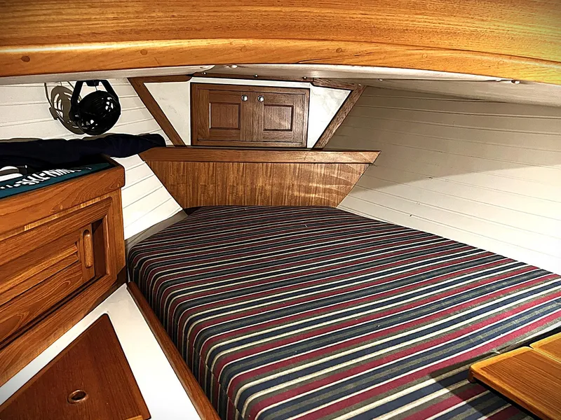 Slide: The Image of Cozy cabin interior of 2000 Pacific Seacraft 37 with striped bedding and wooden cabinetry. - 6