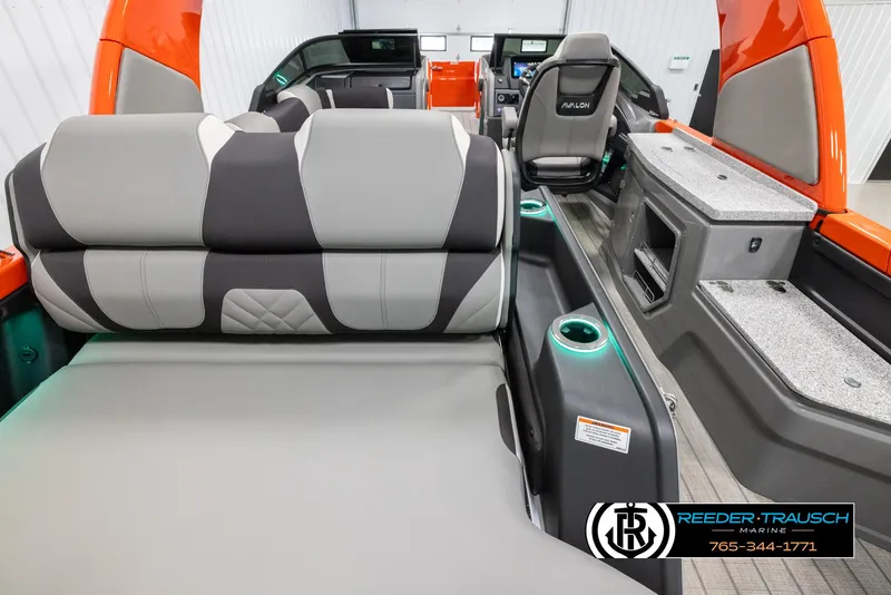 Slide: The Image of 2024 Avalon Excalibur VRB boat interior with gray and black seating, cup holders, and dashboard. - 16