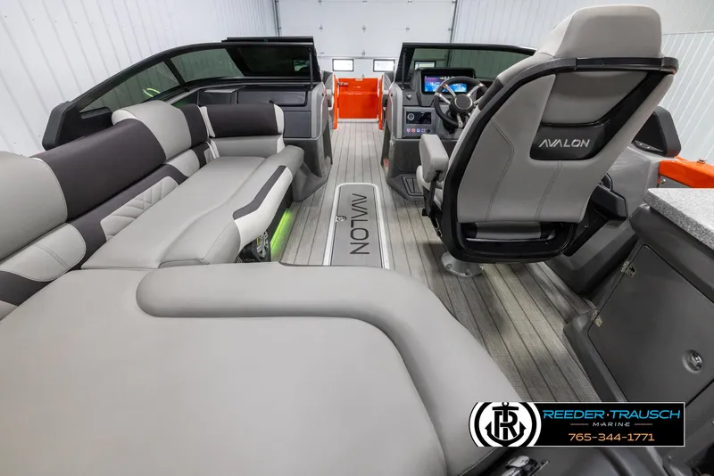 Slide: The Image of 2024 Avalon Excalibur VRB luxury pontoon boat interior with plush seating and modern dashboard. - 17