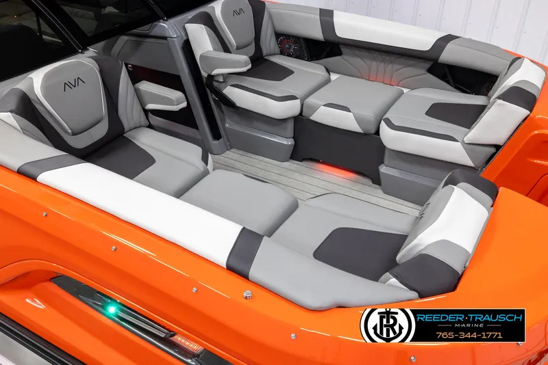 Slide: The Image of 2024 Avalon Excalibur VRB boat interior with gray and white seating, orange exterior, and Reeder-Trausch Marine logo. - 9
