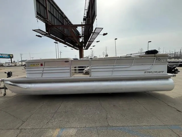 Slide: The Image of 2014 Starcraft Limited 236 pontoon boat in a parking lot. - 2