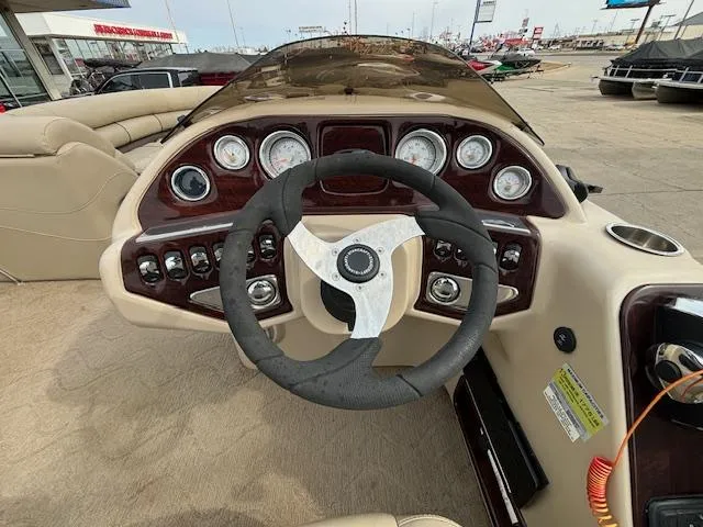 Slide: The Image of 2014 Starcraft Limited 236 boat dashboard with steering wheel and control panel. - 21