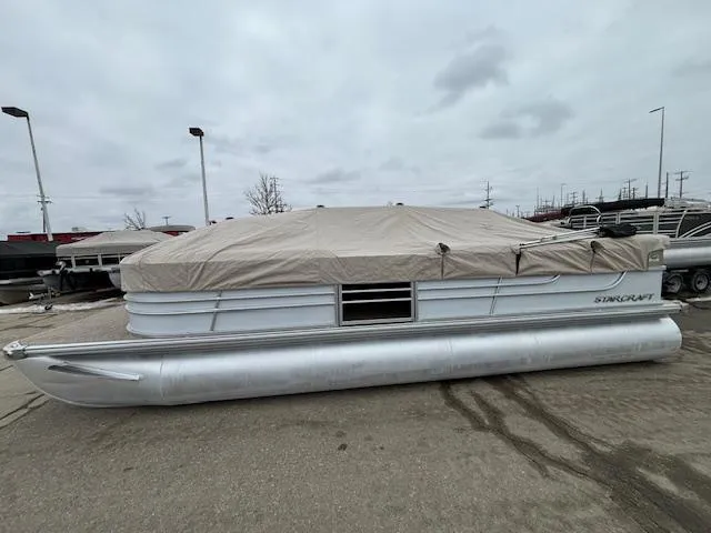 Slide: The Image of 2014 Starcraft Limited 236 pontoon boat with cover in a parking lot. - 25