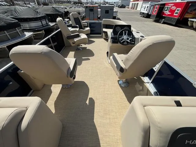Slide: The Image of 2024 Harris Cruiser 230 CWDH pontoon boat interior with beige seating and steering console. - 15