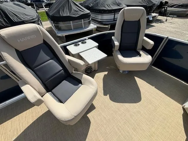 Slide: The Image of 2024 Harris Cruiser 230 CWDH boat interior with two beige and black captain chairs. - 23